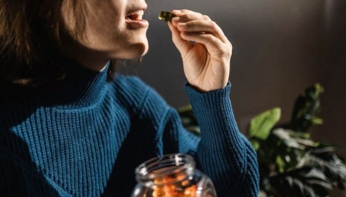 a woman eating CBD edibles out of jar